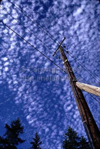 Telephone pole with clouds in the sky. (1971)